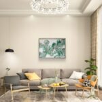 Abstract acrylic painting titled Blushing Ferns by Rebecca Jayne, featuring green and blush pink tones on canvas, framed in oak, set in a living room.